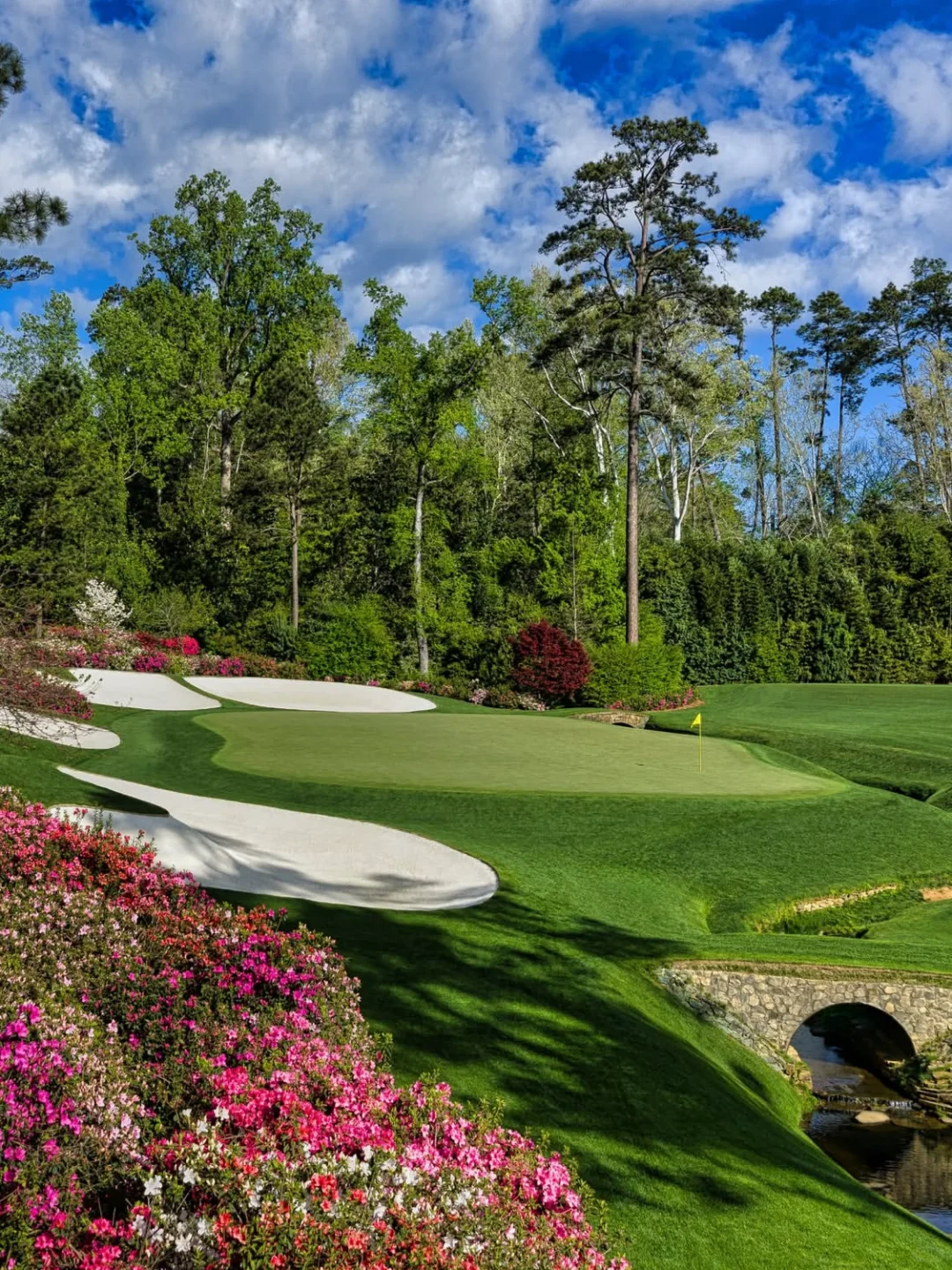 Augusta National hole lined with azaleas and bunkers in bloom