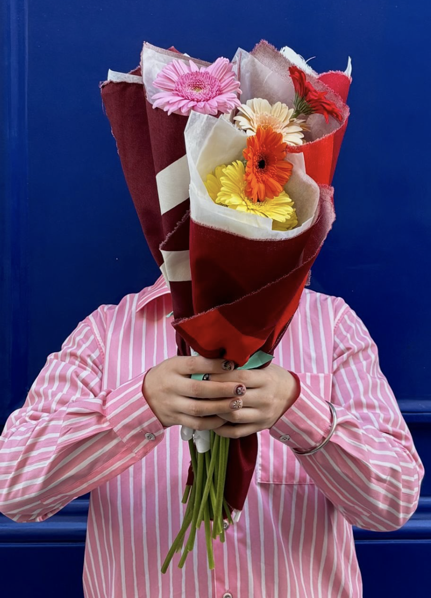 Visitor holding Malbon floral bouquet at store opening